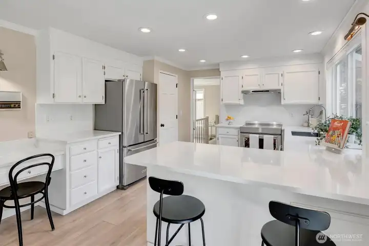 Modern kitchen featuring a spacious peninsula and integrated seating, perfect for casual dining and entertaining. The open-concept design flows seamlessly into the main living area, highlighted by premium  countertops and pendant lighting.