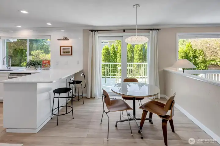 kitchen eating space along with bar seating and sliding doors to deck