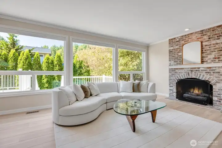 Family room featuring expansive windows that provide a scenic view of the private backyard. This spacious area is perfect for relaxation or entertaining, seamlessly blending indoor comfort with outdoor beauty.