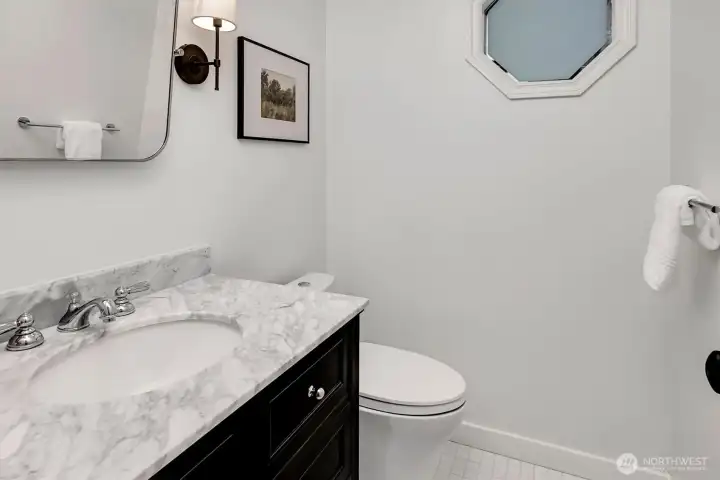 This modern, refreshed half-bath on the main level offers a welcoming and stylish space for visitors.