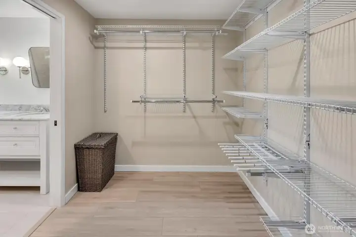 Primary suite walk-in closet with custom shelving,