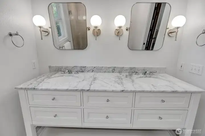 Primary double sink vanity with marble countertop and modern fixtures.