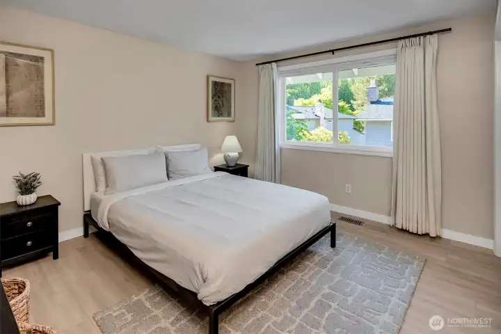Bright and inviting guest bedroom featuring soft neutral tones, a spacious closet and ample natural light, creating a peaceful retreat for visitors.