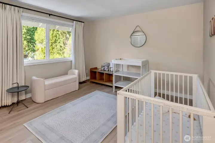 Bright, spacious bedroom featuring large windows that provide ample natural light, perfect for a child's room.