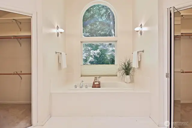 luxurious primary bathroom with walk in closets