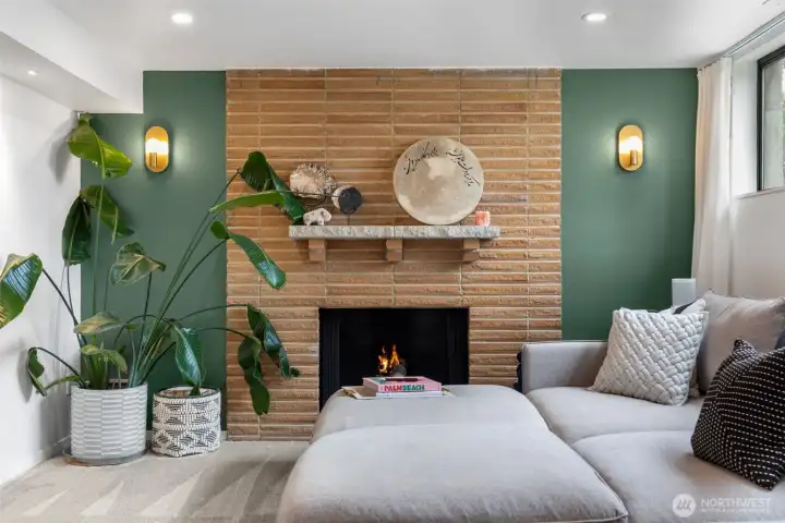 High ceilings and big windows frame the fireplace wall in the lower level living space.