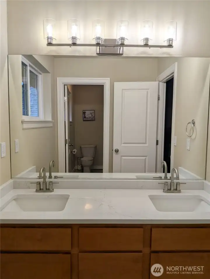 Remodeled hallway bathroom with NEW quartz, undermount sinks, lighting, faucets & herringbone vinyl floors!