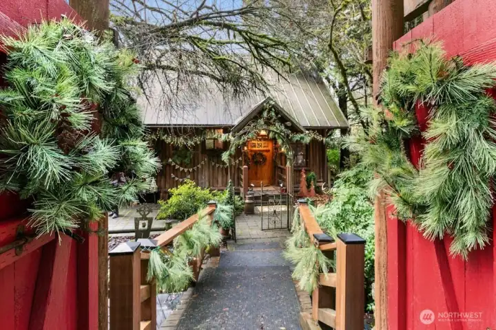 Gated entrance to this storybook 1936 log home and property