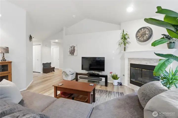 Updated vinyl plank flooring continues into the living area.  Vaulted ceilings and light paint create an open, airy feeling.
