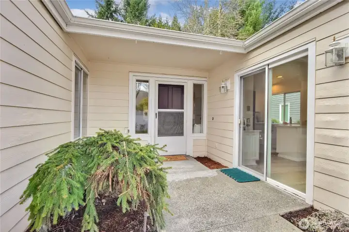 Welcoming entry with front door and slider into kitchen/nook.