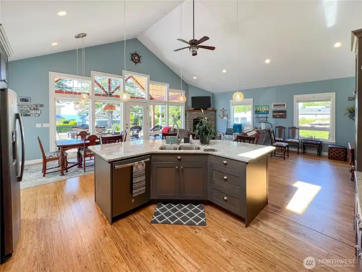 Additional view of the center island, gorgeous wall of windows and beautiful eucalyptus wood floors.