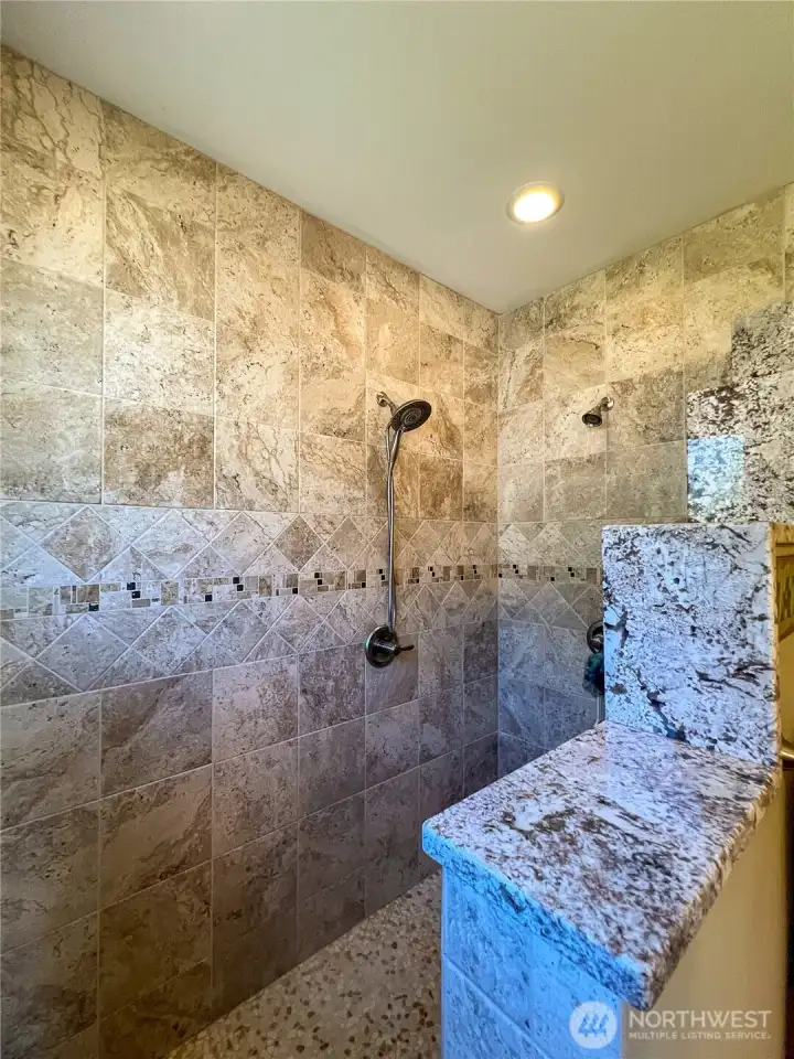The tiled shower with double shower heads and stair stepped tiled wall is absolutely gorgeous.
