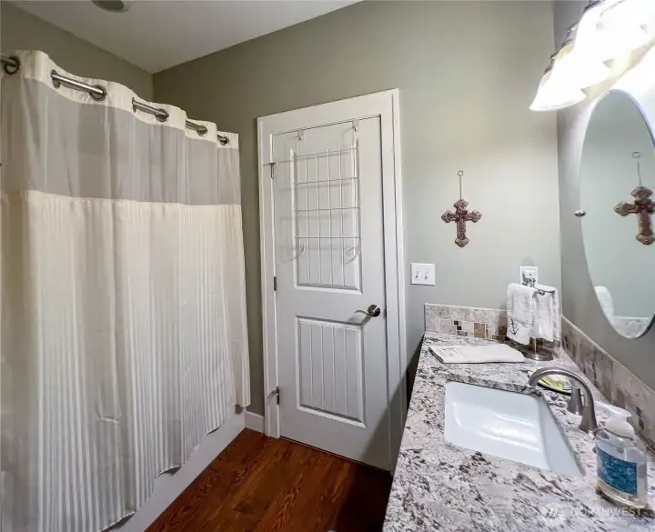 Main floor full bath with access from utility room and hallway.