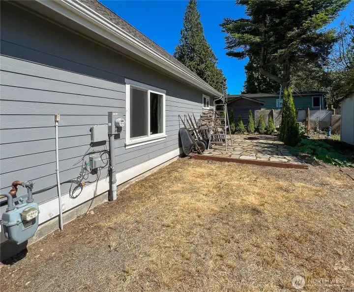 Side of garage is RV parking with full hookups and paver patio with a fire pit.