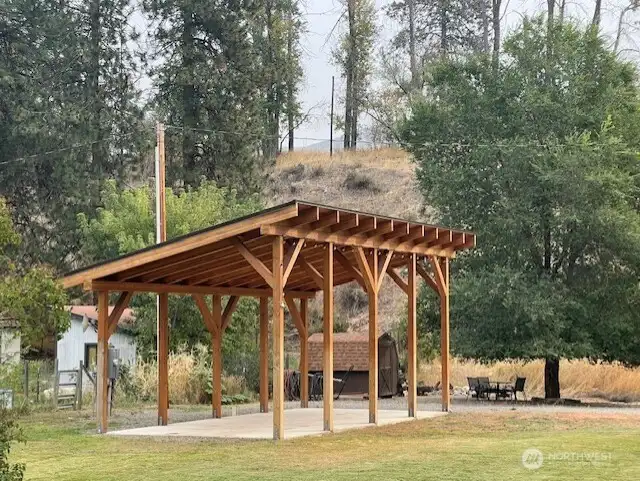 Custom built sturdy RV cover with concrete pad, thoughtfully designed for future conversion to town house or cabin. Spacious covered structure provides shade, storage, and versatility.