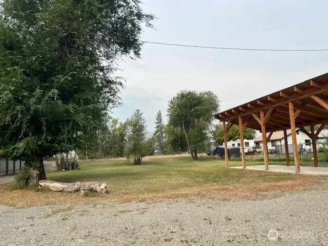 Gravel driveway and landscaped with aspen trees.