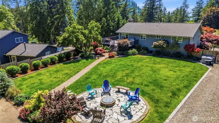 Expansive backyard oasis with lush lawn, entertaining spaces, mature landscaping, and room for gardening, pets, recreation, and outdoor enjoyment.