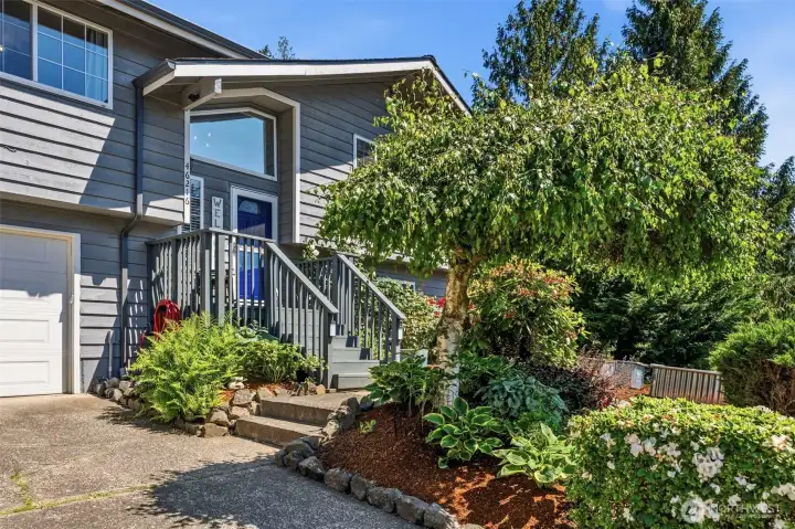 Inviting front entry welcomes you home with manicured landscaping, mature trees, and attractive curb appeal in one of Enumclaw's most sought-after neighborhoods.