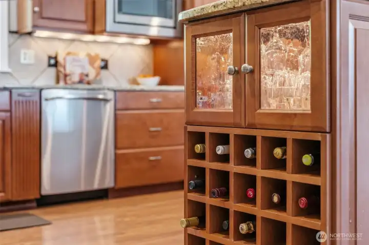 Built-in wine storage and additional cabinetry provide convenience, organization, and added character to the kitchen space.