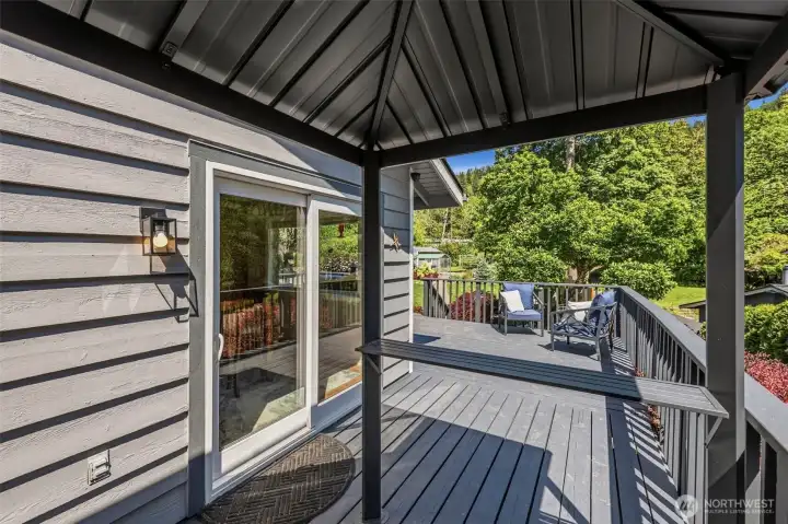 Covering on the deck provides year-round outdoor living space with peaceful views of the surrounding landscape and backyard.