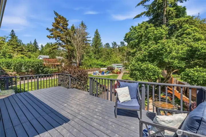 Expansive entertaining deck overlooks the beautifully landscaped yard, creating an ideal setting for gatherings and outdoor enjoyment.