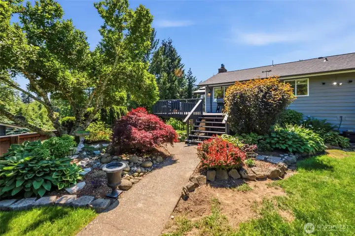 Terraced landscaping and mature gardens add beauty, privacy, and curb appeal throughout the property.