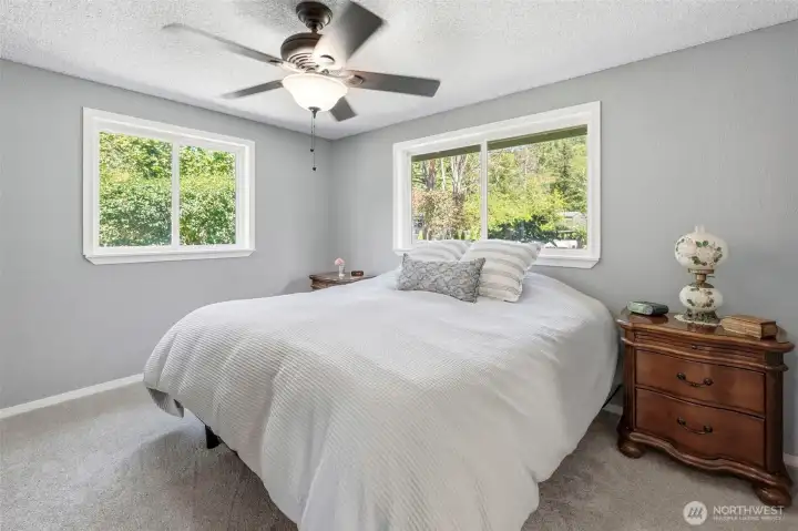 Primary bedroom retreat featuring large windows, natural light, and peaceful views of the  property.
