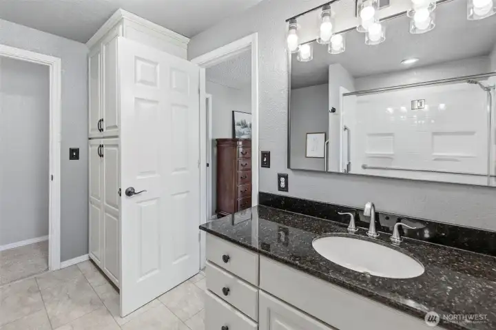 Upstairs bathroom with vanity space, abundant storage, and a clean, timeless design.