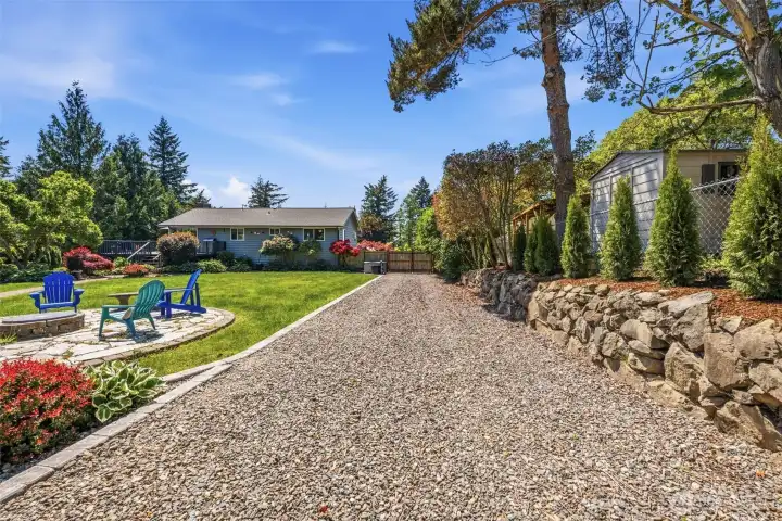 Beautifully landscaped backyard featuring RV or trailer Parking, mature plantings, and exceptional outdoor living space on nearly half an acre.