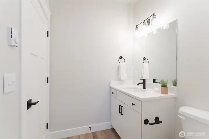 Fresh main-floor bath with quartz counters and black fixtures, ideal for guests or the main-floor bedroom.