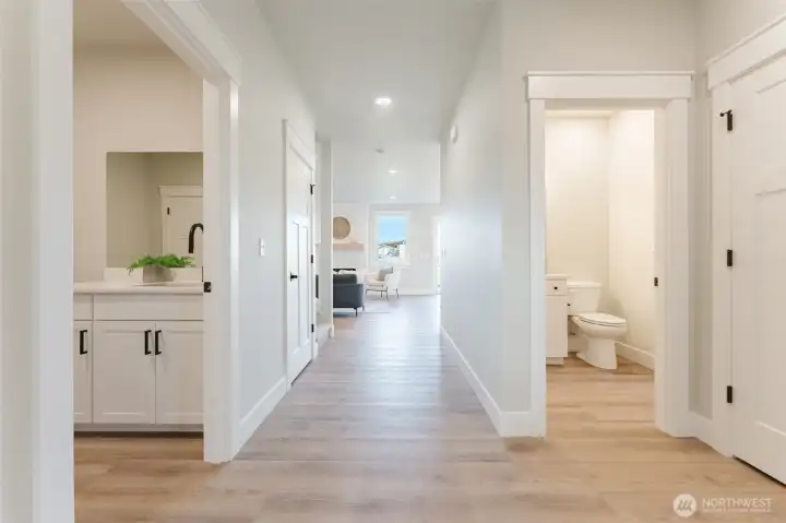 A wide hallway leads from the front door to the open kitchen and living room. Along the way, you'll find the laundry room with access to the garage on the left. To the right are the flex bedroom/office, large storage closet and main floor guest bathroom.