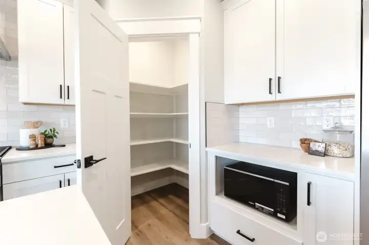 A large walk-in pantry offers tons of shelving for Costco runs, small appliances, and everything you want out of sight.
