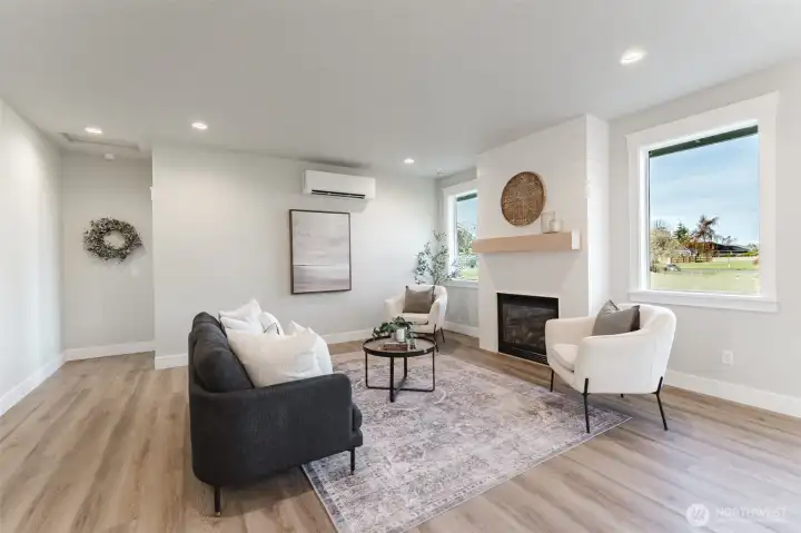 Large windows provide an abundance of natural light in this great space, while the cozy fireplace provides ambiance and warmth.
