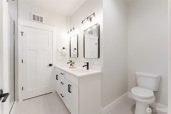 Spa-like primary bath with dual sinks, quartz counters, and black hardware—no sharing counter space here.