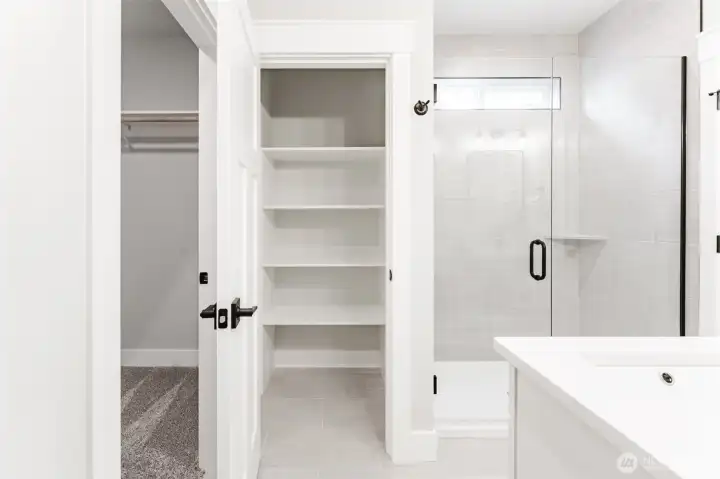 Custom tiled walk-in shower, built-in linen shelving and a spacious walk in closet add even more storage right where you need it.