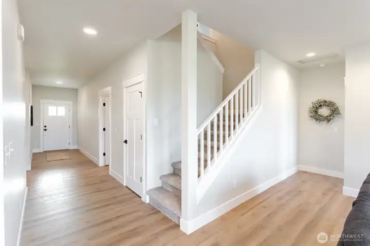 Open hall and staircase connect the main level to the upstairs bedrooms and bath, keeping the home feeling spacious and light.