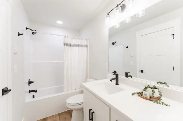 Upstairs full bath with a dual sink vanity and tub/shower combo serving both upstairs bedrooms.