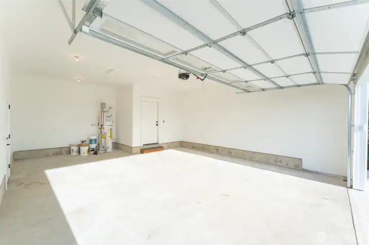 Spacious oversized garage is wired for electric car charger and has a man door to the side of the house.