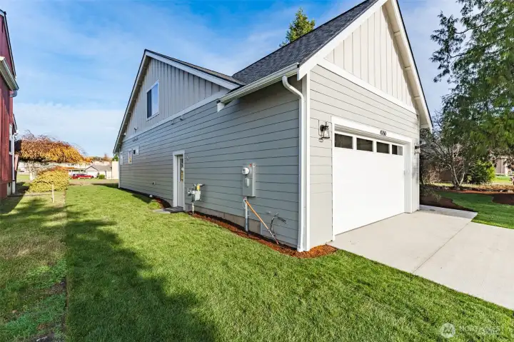 Oversized garage wired for an electric car charger and upgraded with a convenient man door, plus a usable side yard for pets or gardening.
