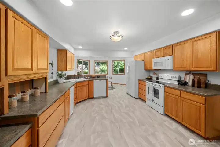 KITCHEN | This spacious kitchen has been refreshed with new vinyl flooring, creamy white paint and can lighting.
