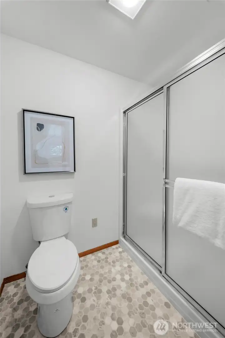 PRIMARY EN-SUITE | You'll appreciate the toilet and shower being tucked away in their own private room. Notice the fresh paint, new toilet and new flooring.