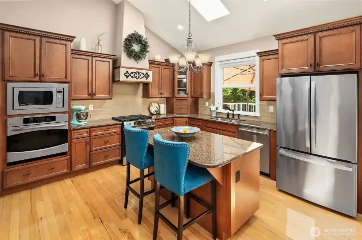 The kitchen delivers full-size double ovens, one gas and one electric, while tall maple cabinetry provides an impressive amount of storage for cookware, pantry staples, and everything needed to keep your space beautifully organized. The kitchen delivers full-size double ovens, one gas and one electric, while tall maple cabinetry provides an impressive amount of storage for cookware, pantry staples, and everything needed to keep your space beautifully organized.
