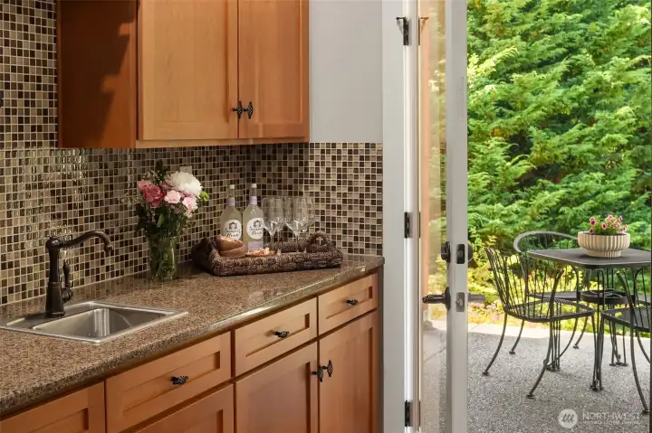 The rich maple cabinetry is continued downstairs, adding warmth and continuity, while the back door invites you out to explore the patio, terraces, and private yard beyond. The rich maple cabinetry is continued downstairs, adding warmth and continuity, while the back door invites you out to explore the patio, terraces, and private yard beyond.