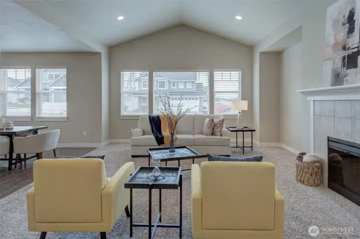 Spacious living room featuring soaring vaulted ceilings, expansive windows, and an abundance of natural light