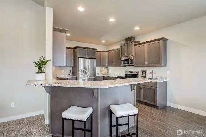 Well-appointed kitchen featuring abundant cabinetry, generous counter space, a peninsula with bar seating, and an efficient layout for everyday living.