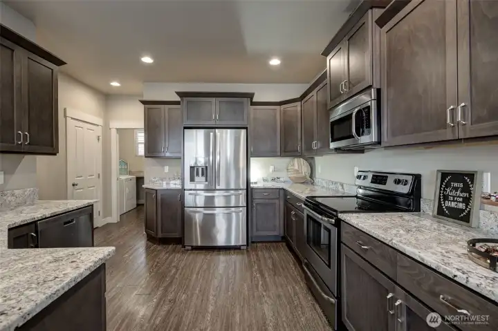 Open kitchen with a peninsula eating bar, bar seating, and seamless flow into the dining area—perfect for entertaining family and friends.