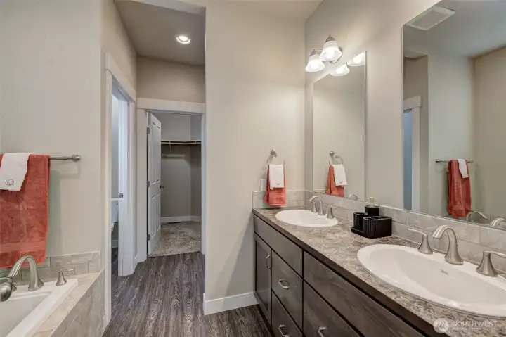 Spacious 5-piece primary ensuite featuring dual vanities, a relaxing soaking tub, separate shower, and abundant storage.