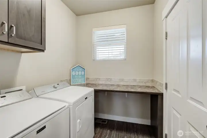 Dedicated laundry room with storage and direct access to the oversized garage.