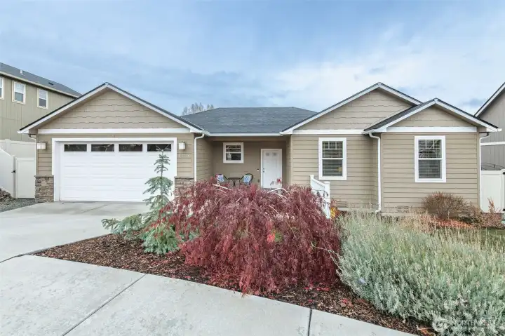 Beautifully landscaped front yard with mature plantings, lush lawn, irrigation, and exceptional curb appeal.