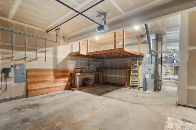 The spacious two-car garage is designed with built-in shelving, offering ample storage space for tools, sports equipment, and seasonal items.